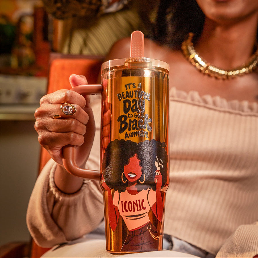 Copper Luxe HydraLock tumbler with an illustrated Black woman lifting her full afro with a pick, wearing gold hoops and a white crop top reading ICONIC, beneath the black affirmation It's a Beautiful Day to Be a Black Woman